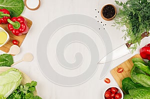 Healthy vegeterian ingredients for spring fresh green salad and kitchenware on white wood board, top view, copy space.