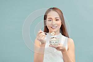 Healthy Weight Loss Food.  Young woman eating yoghurt, raisins and oatmeal