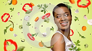 Healthy weight loss. Smiling African American girl on green background, collage with floating veggies. Copy space