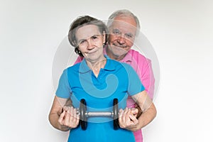 Healthy white fit smiling happy senior male female couple stand and posing indoors, enjoy life together