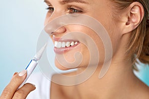 Healthy White Teeth. Beautiful Smiling Woman Using Whitening Pen