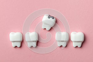 Healthy white teeth and removing tooth with caries against pink backgroundhook.