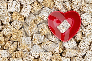 Healthy whole grain cereal background with a heart bowl