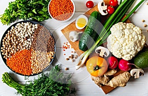 Healthy wholesome vegetarian diet food. Plate with raw chickpeas beans and lentils on a light background on a cutting board with