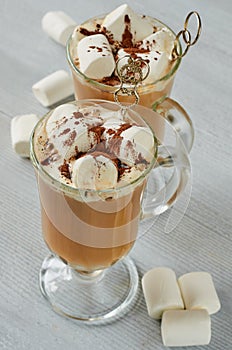 Healthy winter Christmas cocktail - hot cocoa drink with marshmallows and chocolate powder in the glasses on the gray table