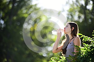 Healthy woman drinking water from bottle. Stay hydration concept. Unhidrated. Unity with nature, outdoor.