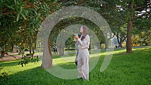 Healthy woman hydrating park leisure. Girl drinking lemon water in green garden