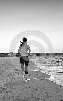 Healthy woman jogger on seashore in evening running