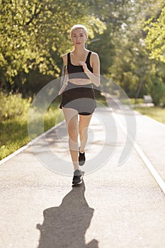Healthy woman jogging in sunny park