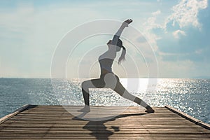 Healthy woman lifestyle balanced yoga ball practicing meditate and energy on the bridge in morning the seashore.