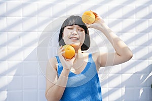 Healthy woman with oranges in hands