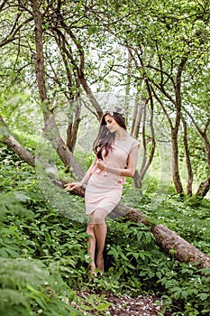 Healthy woman outdoors. Beauty girl female model brunette wearing flowers wreath in spring blossom garden