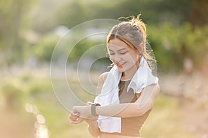 Healthy woman relax after cool down and looking smart watch for check timing run. Woman workout after fitness and
