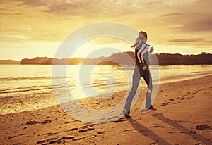 Healthy woman running on the beach at sunset