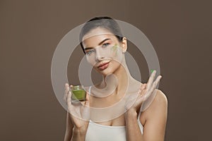 Healthy woman spa model applying organic cream to her skin. Facial treatment and skin care concept