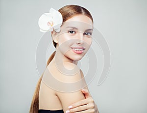 Healthy woman spa model with long hair, clear skin and orchid