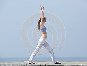 Healthy woman stretching body at the beach