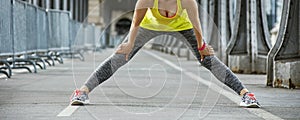 Healthy woman stretching on Pont de Bir-Hakeim bridge in Paris