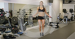 Healthy woman sweats while she jumping rope in gym