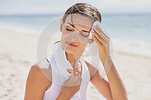 Healthy woman wipe out her sweat with towel after workout