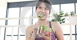 Healthy woman workout holding organic salad bowl healthy lifestyle. Wellness Asian women dressing organic green salad tomato veget