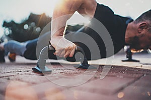 Healthy workout lifestyle concept.Training outdoors.Handsome sport athlete man doing pushups in the park on the sunny