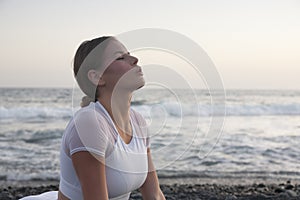 Healthy with Yoga Concept. Attractive young woman practice Cobra Pose on the beach during sunset.