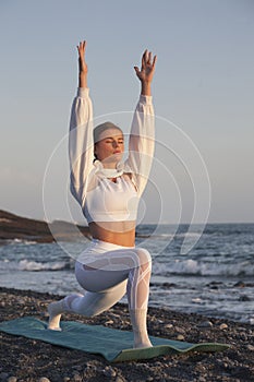 Healthy with Yoga Concept. Attractive young woman practice Warrior Pose Virabhadrasana in Yoga on sunset