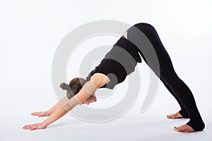 Healthy yoga stretching woman does a downward facing dog. This is part of a series of various yoga poses by this model