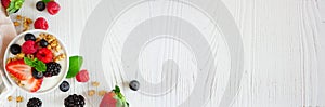 Healthy yogurt with fresh berries and granola banner with corner border against a white wood background with copy space