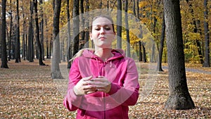 Healthy young adult woman warms up outdoors in park