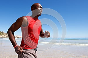 Healthy young african guy running along the seashore