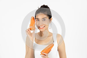 Healthy young Asian woman holding carrot over white isolated background. Vegetarian, Healthy lifestyle, Fitness and health care