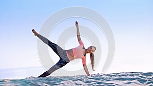 Healthy, young beautiful woman doing exercises for oblique abdominal press muscles,, on the beach, at sunrise, Makes