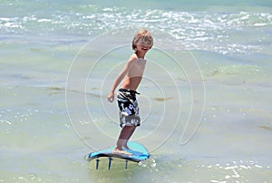 Healthy young boy learning to surf