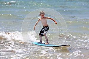 Healthy young boy learning to surf