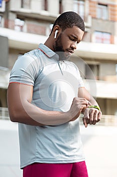 Healthy young man looking at his fitness tracker