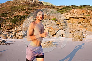 Healthy young man running on beach