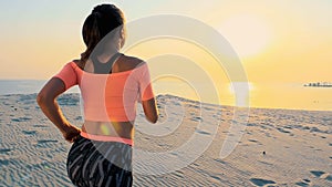 Healthy, young sports beautiful woman runs along the sand, on the beach, in summer, towards the sun, at the sunrise.