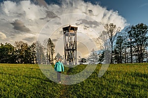 Healthy young sporty girl walking to lookout tower called Na Vetrne Horce, Broumov region,Czech Republic. Active lifestyle travel photo