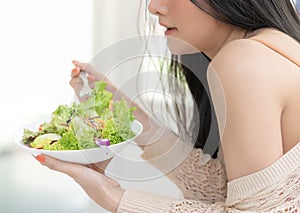 Healthy young woman is eating green salad for healthy lifestyle food concept