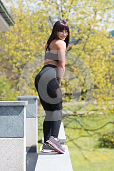 Healthy Young Woman Flexing Muscles Outdoors