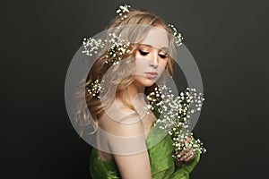 Healthy young woman with flowers on black background