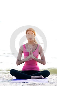 Healthy young woman lifestyle exercising vital meditate and practicing yoga at seashore, nature background.