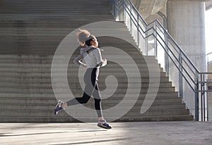 Healthy young woman running in urban environment