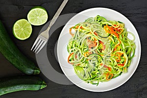 Healthy zucchini noodle dish with carrots and lime