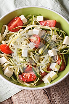 Healthy zucchini pasta with cheese and tomato close up vertical