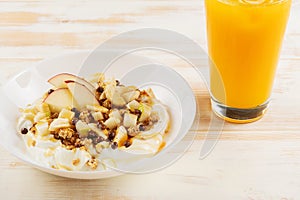 Healthy Î’reakfast concept. Yogurt with flakes, fruits and honey on wooden background