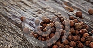 A heap of allspice, on wooden surface. Closeup view.