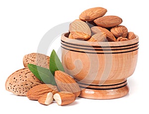 Heap of almonds in their skins and peeled with leaf isolated on white background